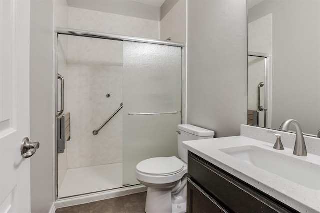 bathroom with a shower with door, vanity, tile patterned floors, and toilet