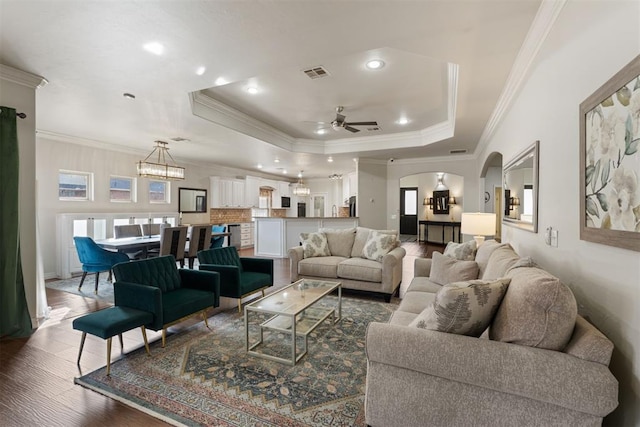 living room with hardwood / wood-style floors, a tray ceiling, and plenty of natural light