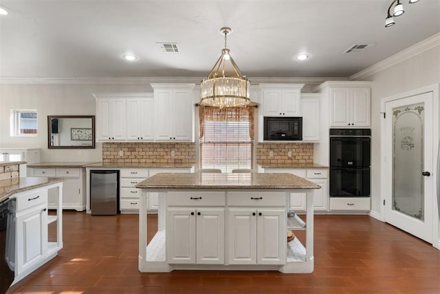 kitchen with white cabinetry, light stone counters, decorative light fixtures, a kitchen island, and black appliances