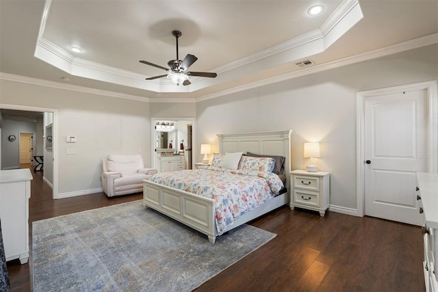 bedroom with dark hardwood / wood-style floors, ornamental molding, and a tray ceiling