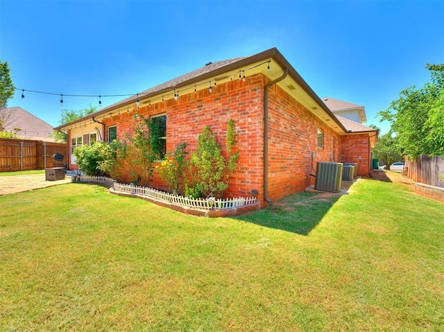 view of home's exterior with a yard and central AC