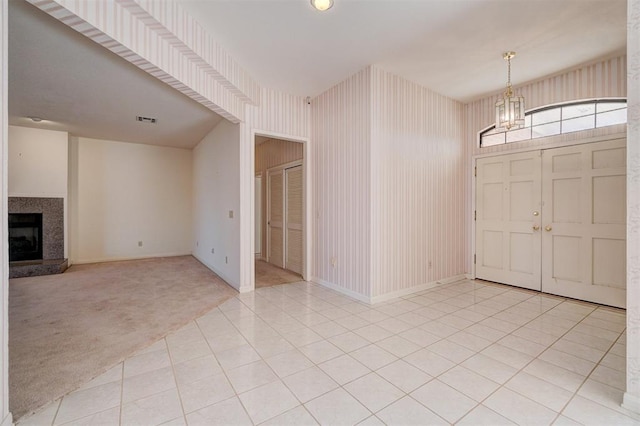 foyer featuring light colored carpet and a notable chandelier