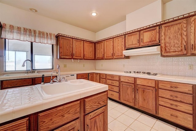 kitchen featuring tasteful backsplash, sink, light tile patterned floors, and white gas cooktop