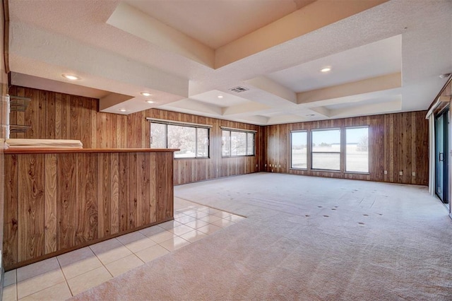 interior space featuring light colored carpet, wooden walls, and a wealth of natural light