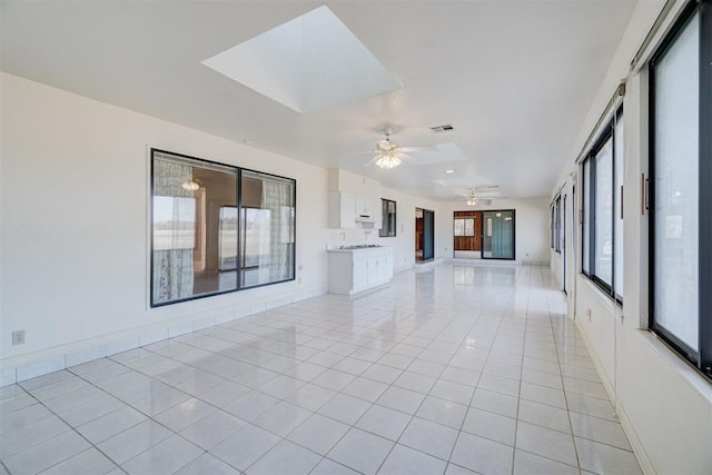 unfurnished living room with light tile patterned floors and ceiling fan