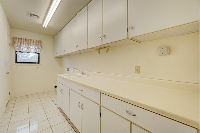 laundry area featuring cabinets, hookup for a washing machine, sink, and light tile patterned floors