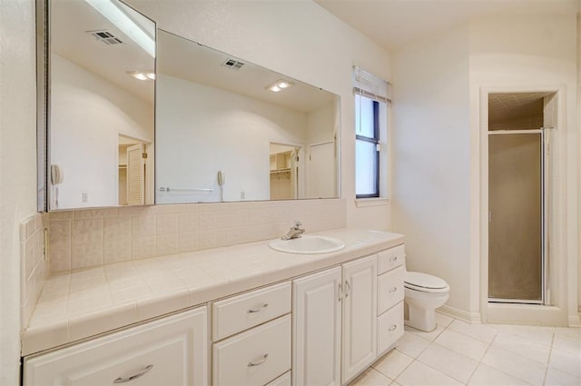 bathroom featuring a shower with door, vanity, tile patterned floors, and toilet