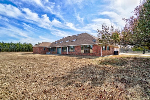 rear view of house featuring a lawn