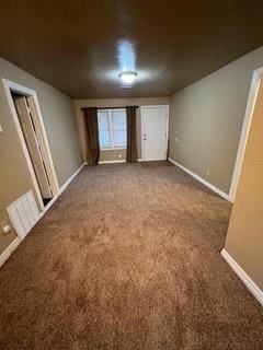 unfurnished bedroom with dark colored carpet