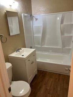 full bathroom with hardwood / wood-style flooring,  shower combination, toilet, and vanity