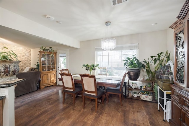 dining room with dark wood-type flooring and a chandelier