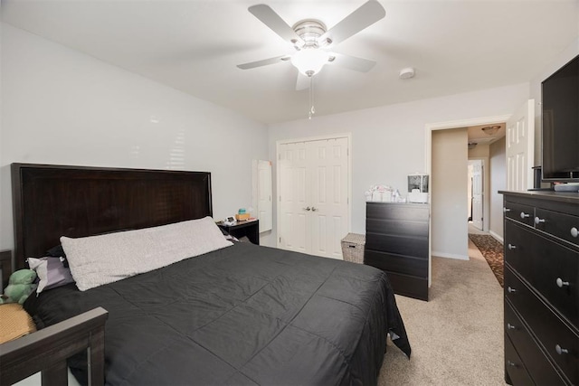 carpeted bedroom featuring ceiling fan and a closet