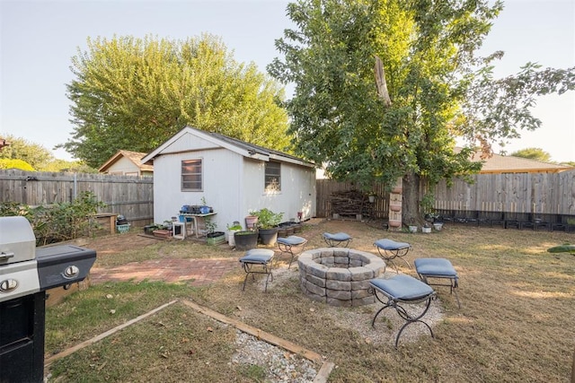 view of yard with an outbuilding and a fire pit