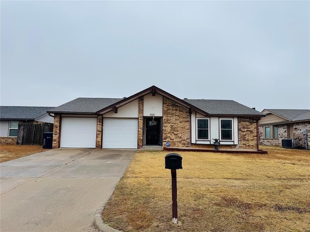 ranch-style home featuring cooling unit, a garage, and a front yard