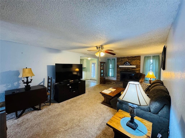 carpeted living room with ceiling fan, a textured ceiling, and a fireplace