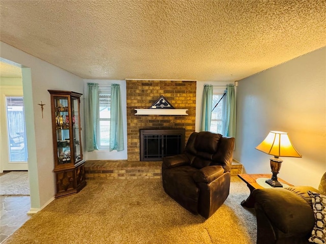 carpeted living room featuring a brick fireplace, a wealth of natural light, and a textured ceiling