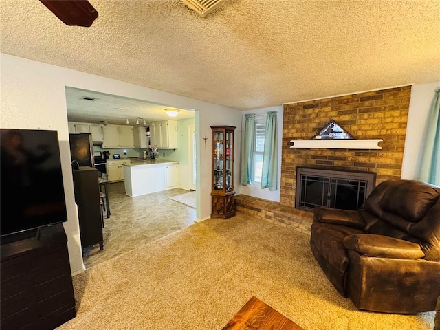 carpeted living room featuring a brick fireplace and a textured ceiling