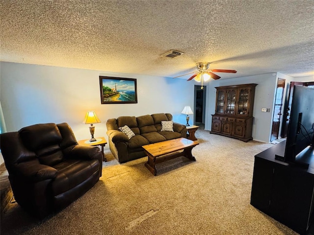 living room featuring ceiling fan, carpet, and a textured ceiling