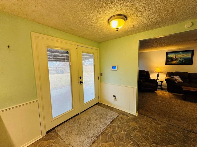 doorway with french doors and a textured ceiling