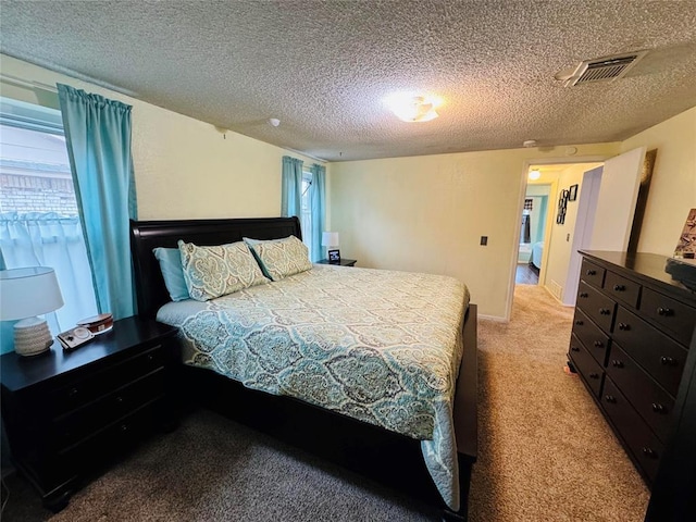 bedroom with light colored carpet and a textured ceiling