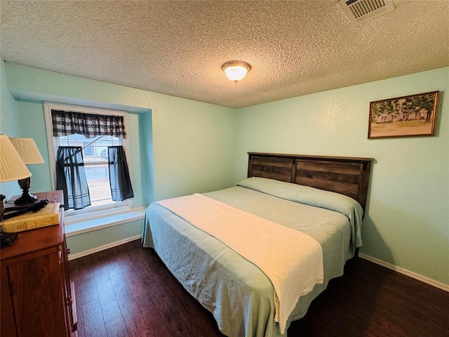 bedroom featuring dark wood-type flooring and a textured ceiling