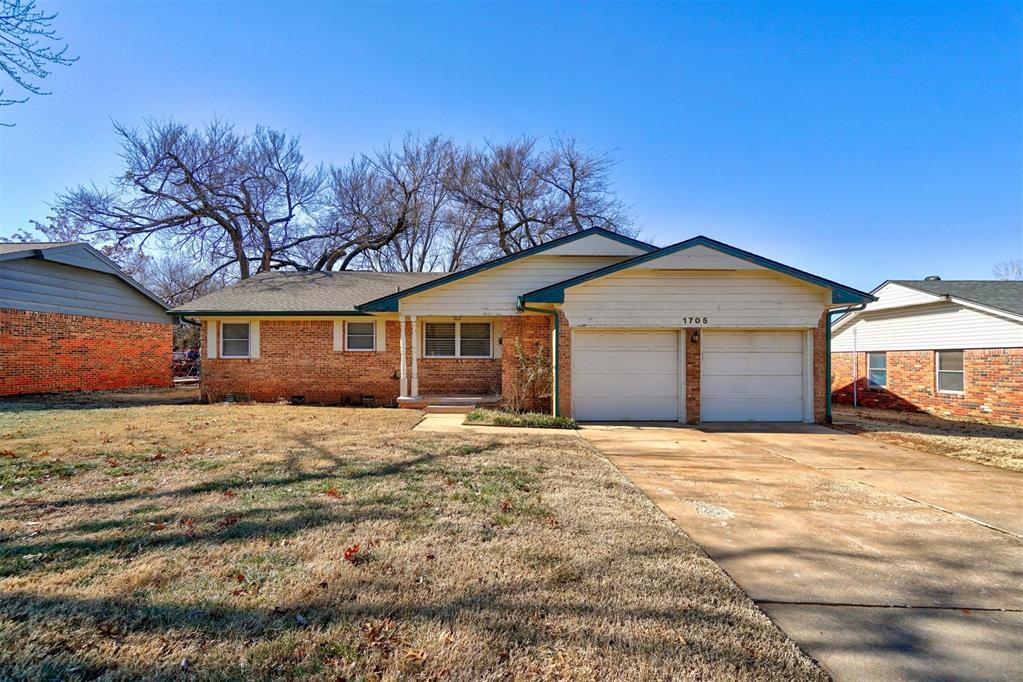 ranch-style home featuring a garage and a front yard