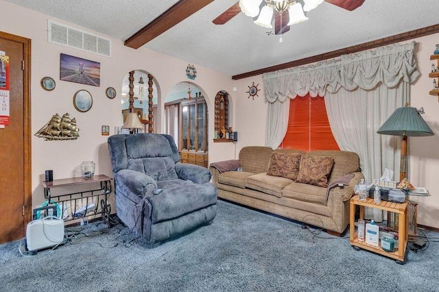 living room featuring ceiling fan, beam ceiling, and a textured ceiling