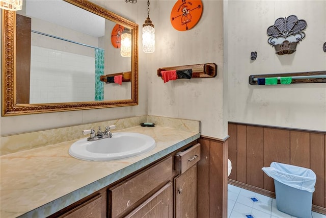 bathroom with vanity, wooden walls, toilet, and walk in shower