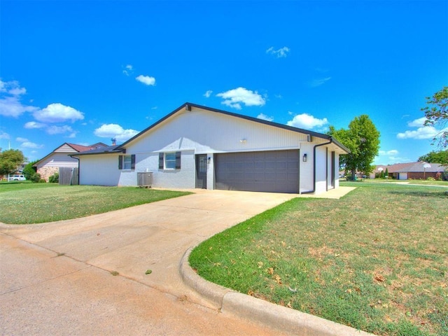 single story home featuring cooling unit, a garage, and a front yard