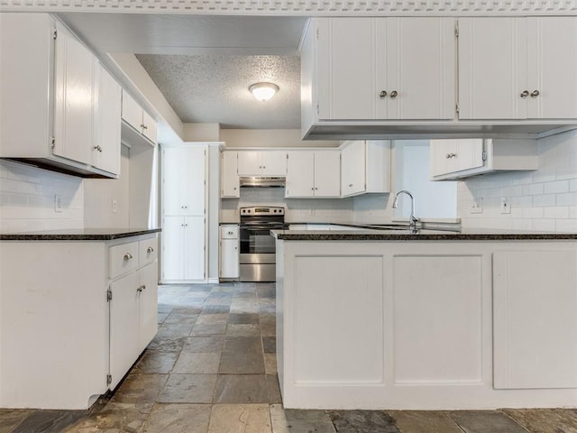 kitchen featuring dark stone countertops, sink, stainless steel range with electric cooktop, and white cabinets