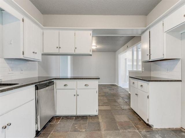 kitchen featuring white cabinetry, stainless steel dishwasher, dark stone counters, and kitchen peninsula