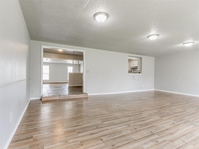 spare room with light hardwood / wood-style floors and a textured ceiling