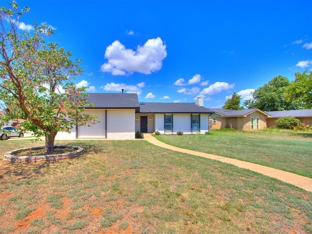 ranch-style home with a front yard, an attached garage, and a chimney