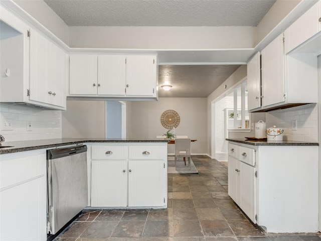 kitchen with dark countertops, dishwasher, white cabinets, and a peninsula