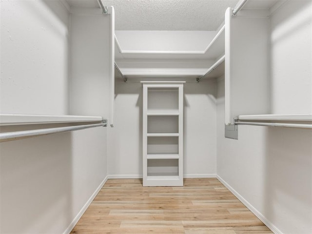 walk in closet with wood finished floors