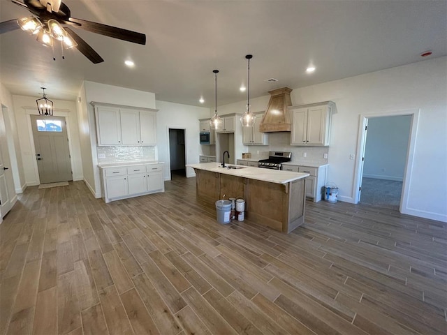 kitchen featuring a spacious island, stainless steel electric range oven, hanging light fixtures, and white cabinets