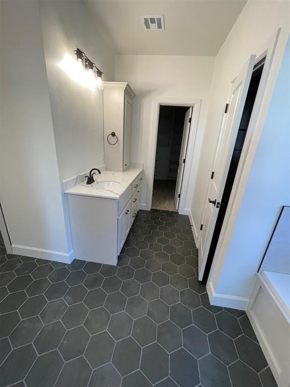 bathroom with tile patterned flooring, vanity, and a bathtub