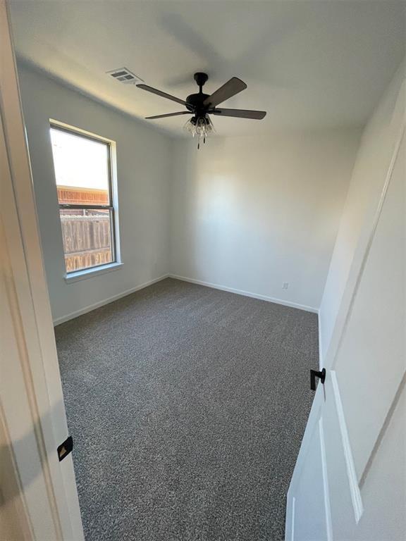 carpeted empty room featuring ceiling fan