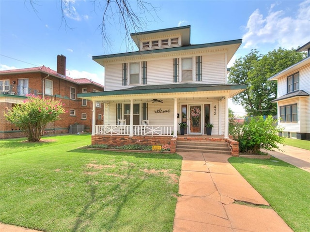 italianate house featuring a front yard, central air condition unit, and covered porch