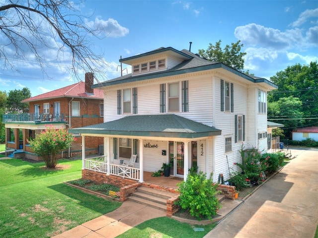 view of front facade with a front yard and covered porch