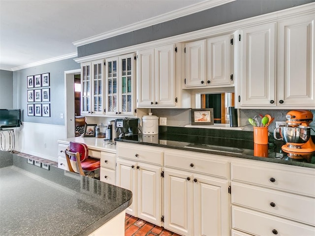 kitchen with crown molding, built in desk, decorative backsplash, and white cabinets