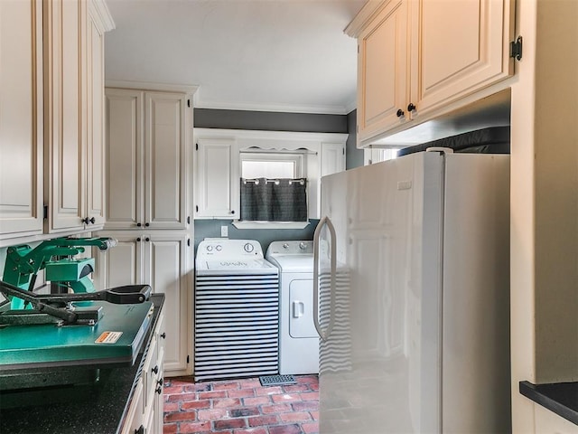 washroom featuring separate washer and dryer, ornamental molding, and cabinets