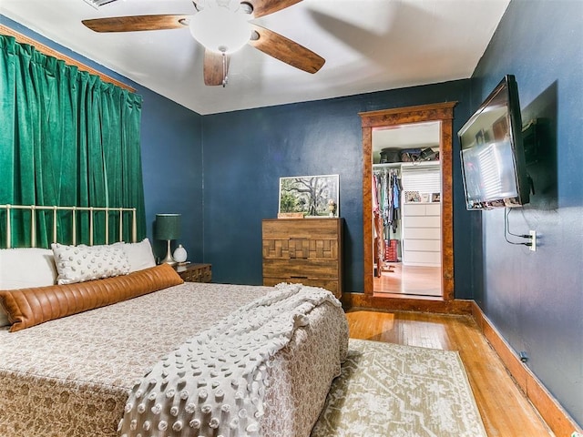 bedroom featuring ceiling fan, wood-type flooring, and a closet