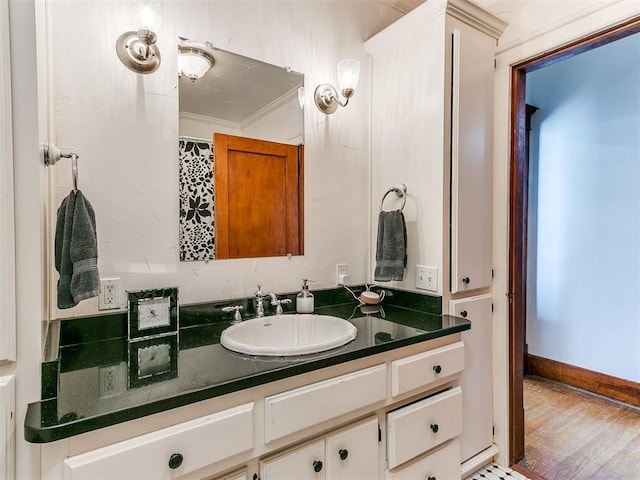 bathroom featuring vanity, hardwood / wood-style floors, and ornamental molding