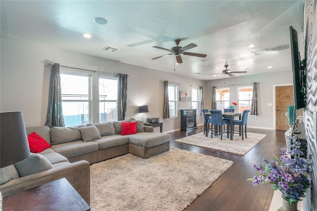 living room featuring dark wood-type flooring, recessed lighting, visible vents, and baseboards