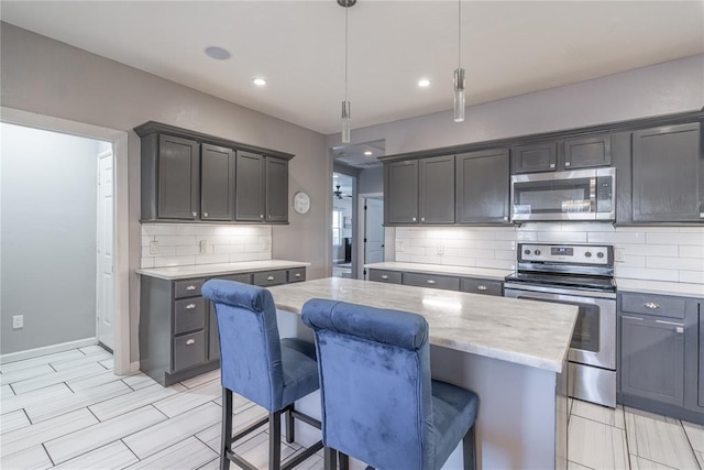 kitchen with tasteful backsplash, light stone counters, a center island, stainless steel appliances, and a kitchen bar