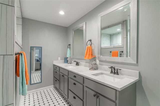 bathroom with recessed lighting, a sink, baseboards, and double vanity