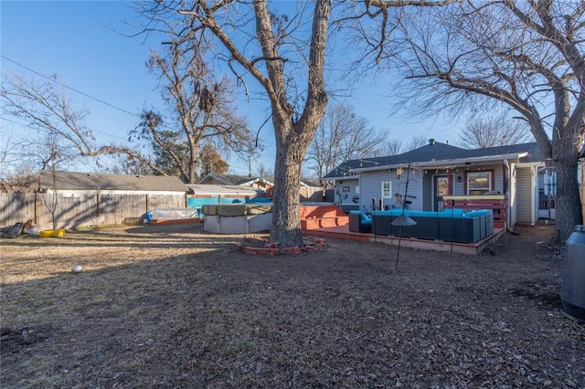 view of yard with a fenced backyard, a jacuzzi, a wooden deck, and an outdoor hangout area