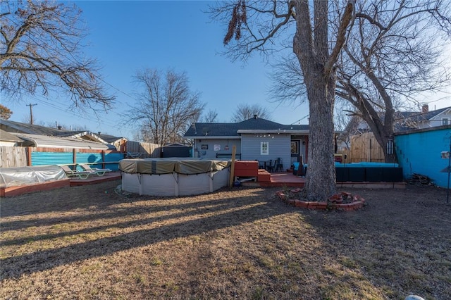 view of yard with an outdoor hangout area, fence, a wooden deck, and a covered pool