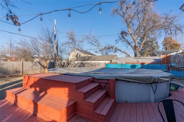 deck with a fenced backyard and a hot tub